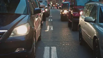 A congested city street lined with cars stuck in traffic at dusk, showcasing urban life.